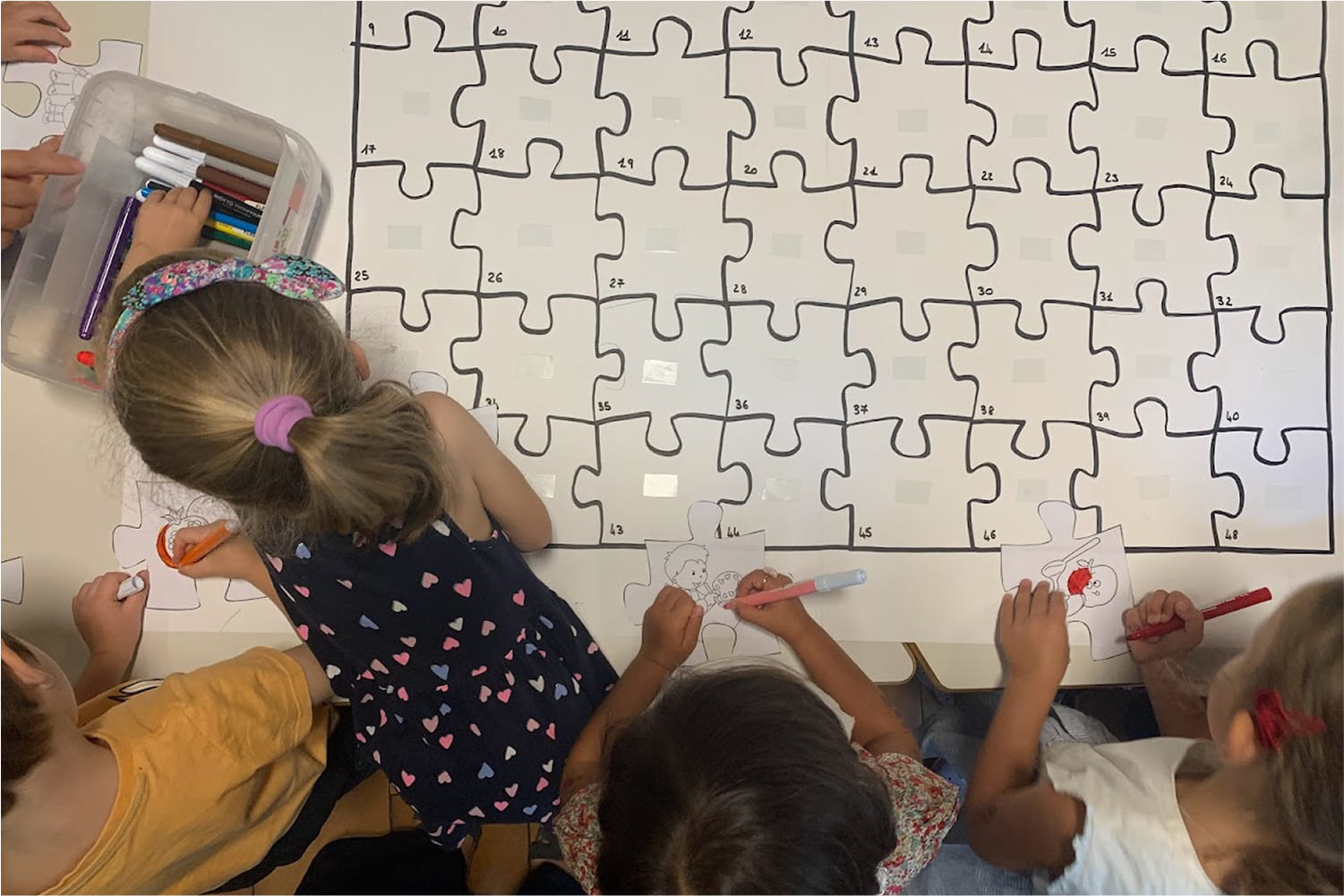 Chi-siamo-scuola Gruppo di bambini che colorano un puzzle